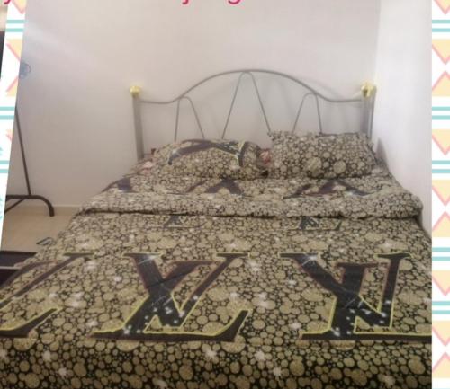 uma cama com as letras xxx nela em Sobey Laris Homestay RANTAU PANJANG SWIMMING POOL em Pasir Mas
