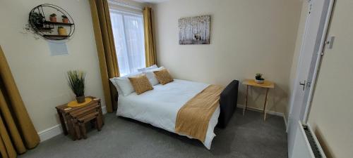 a small bedroom with a bed and a window at Data House Holiday Apartment in Atherstone
