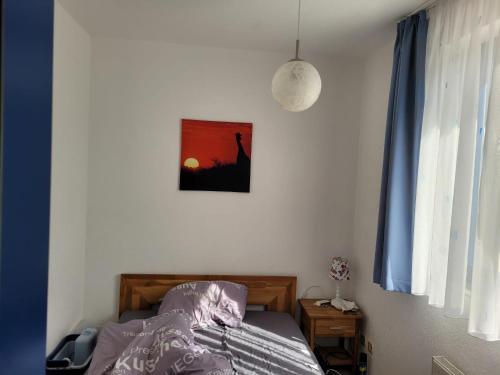- une chambre avec un lit et une photo sur le mur dans l'établissement Rheinblick Waldshut 2, à Waldshut-Tiengen