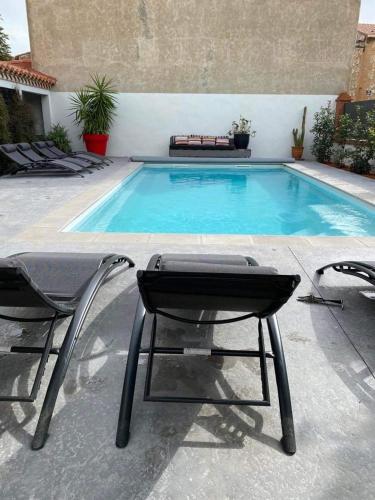 deux chaises assises à côté d'une piscine dans l'établissement LA CASA SANILLS, à Saint-Hippolyte