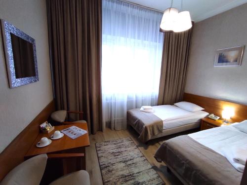 a hotel room with two beds and a window at Hotel Polonia in Rzeszów
