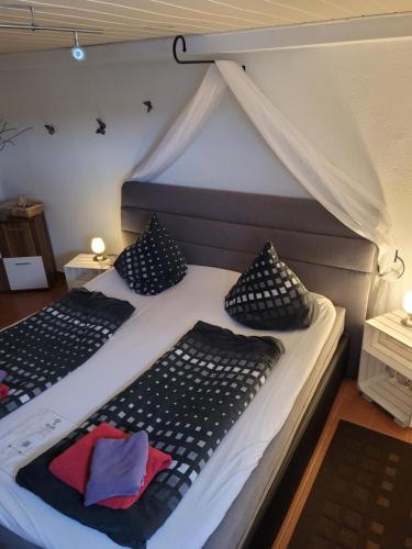 a bedroom with two beds with black and white pillows at Gästezimmer Haus Talblick in Lautenthal