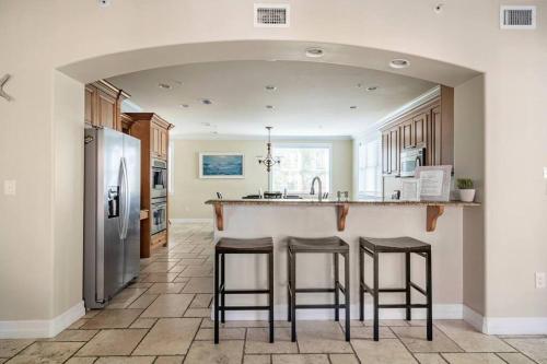 a kitchen with a counter and stools at a bar at Luxury Beach House - steps to the beach in Clearwater Beach