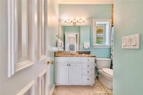 a bathroom with a sink and a toilet and a mirror at Luxury Beach House - steps to the beach in Clearwater Beach