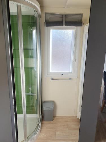 Elle comprend une petite salle de bains pourvue d'une fenêtre et de toilettes. dans l'établissement Charmant mobil-home, à Rocbaron
