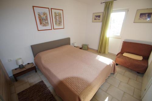 a bedroom with a bed and a chair and a window at Holiday apartment Eric in Pula