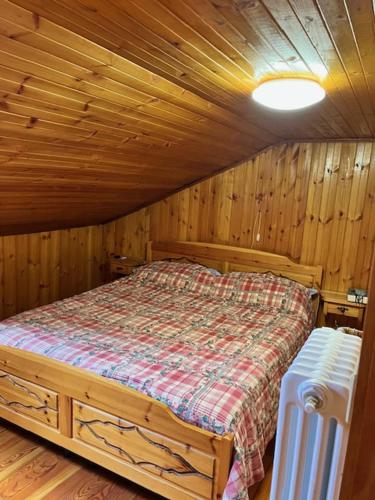 ein Schlafzimmer mit einem Bett in einer Holzhütte in der Unterkunft Maddy in La Magdeleine