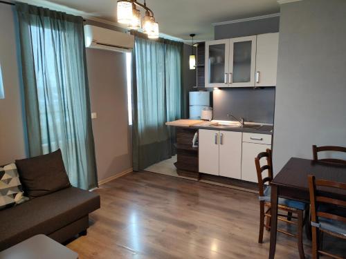 a living room with a couch and a table and a kitchen at Mladost 1 Apartment near the metro in Sofia