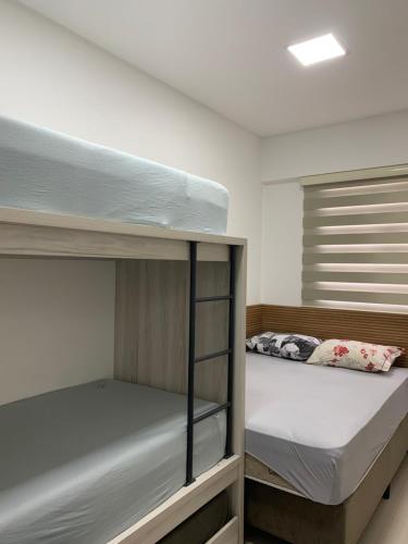 a bedroom with two bunk beds in it at Apto aconchegante e elegante Morretes itapema in Meia Praia