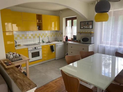 a kitchen with yellow cabinets and a table in it at Appartamento Mont Fleury in Valtournenche