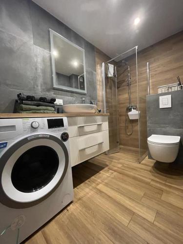 a bathroom with a washing machine and a toilet at Apartament z Widokiem 5 in Chełm