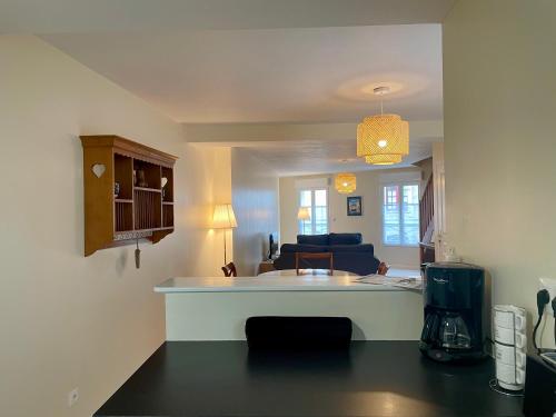a kitchen and living room with a couch and a table at Le Mulberry in Bayeux