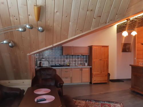 una cucina con armadi in legno e un tavolo in una stanza di Apartamenty i pokoje gościnne Nowita a Zakopane