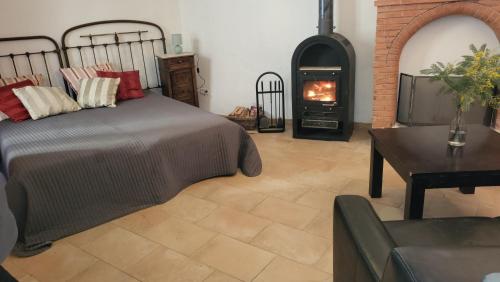 a bedroom with a bed and a wood stove at L'Esprit du vallon de Berlou in Berlou