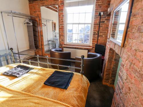 a room with a bed and a brick wall at 16 St Sepulchre Street in Scarborough