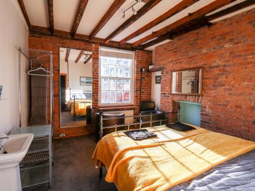 um quarto com uma cama numa parede de tijolos em 16 St Sepulchre Street em Scarborough