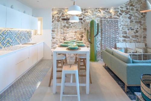 eine Küche und ein Wohnzimmer mit einem Tisch und einem Sofa in der Unterkunft Veronique by Dimore in Sicily in Syrakus