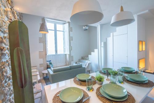 ein Wohnzimmer mit einem Tisch und grünen Platten darauf in der Unterkunft Veronique by Dimore in Sicily in Syrakus