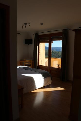 sypialnia z łóżkiem i dużym oknem w obiekcie Hotel Balcó del Priorat w mieście La Morera de Montsant