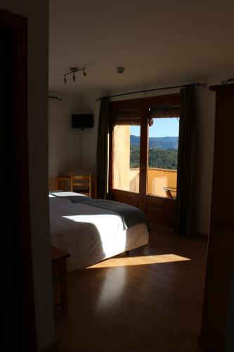 a bedroom with a bed and a large window at Hotel Balcó del Priorat in La Morera de Montsant