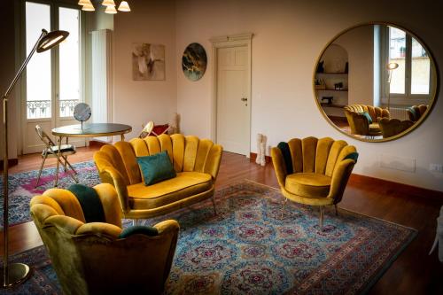 ein Wohnzimmer mit gelben Stühlen und einem Spiegel in der Unterkunft Borgo Antico B&b in Foggia