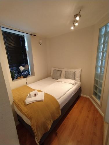 Un dormitorio con una cama con una toalla blanca. en Central bus station apartment, wifi, tv, en Narvik