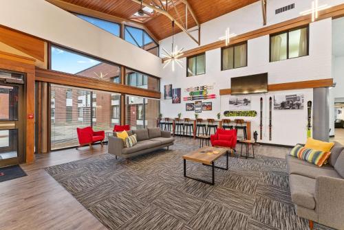 a living room with couches and red chairs at Ramada by Wyndham Cedar City in Cedar City
