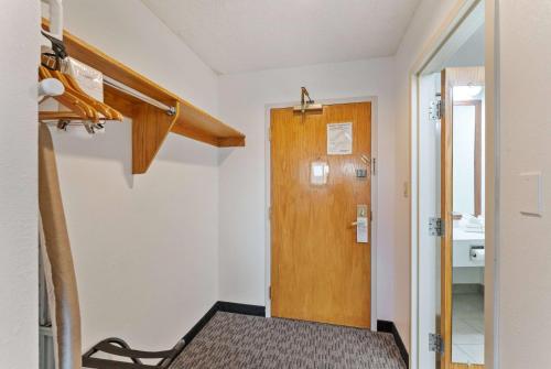 a small room with a wooden door and a table at Ramada by Wyndham Cedar City in Cedar City