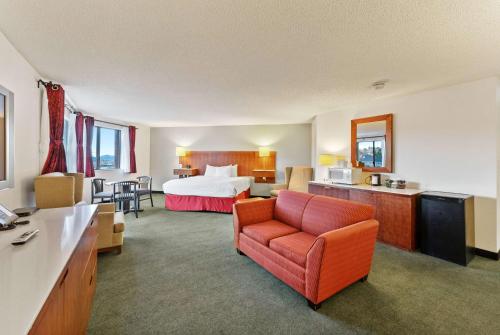 a hotel room with a bed and a couch at Ramada by Wyndham Cedar City in Cedar City