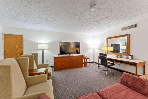 a living room with a couch and a desk at Ramada by Wyndham Cedar City in Cedar City