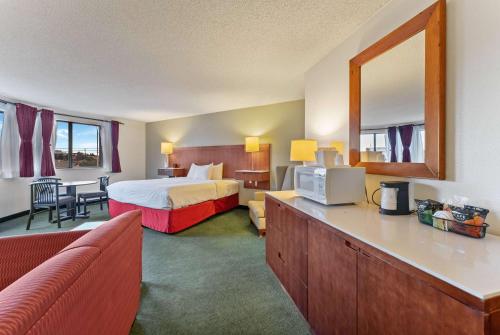a hotel room with a bed and a mirror at Ramada by Wyndham Cedar City in Cedar City