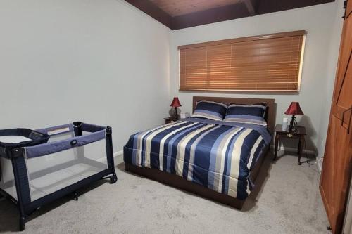 a bedroom with a blue and white bed and a window at Entire one bedroom apartment in Annandale