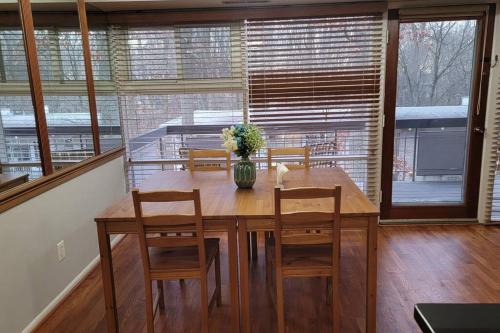 a dining room table with chairs and a vase with flowers at Entire one bedroom apartment in Annandale