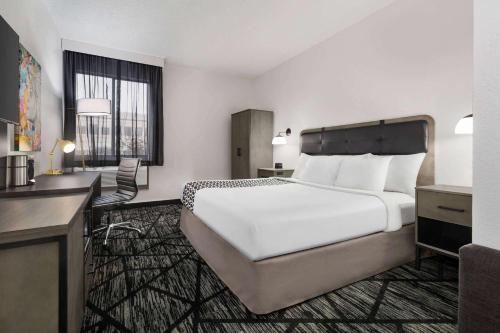 a hotel room with a large bed and a desk at La Quinta by Wyndham Cleveland Airport West in North Olmsted