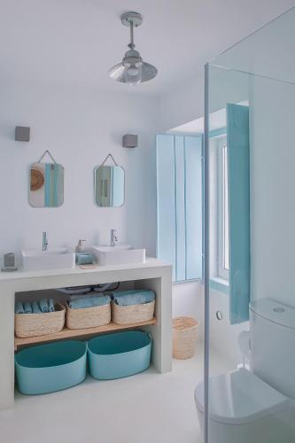a bathroom with a sink and a toilet and a mirror at Casa Azul do Olival in Alcácer do Sal
