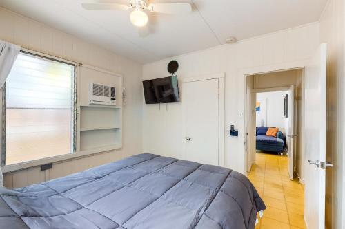 a bedroom with a blue bed and a window at Monsarrat Apt D - 30-Night Minimum in Honolulu