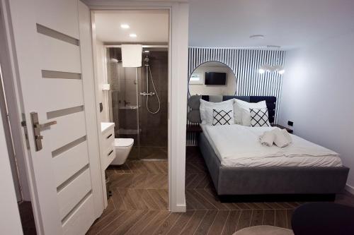 a bedroom with a bed and a bathroom with a shower at Willowa NO. 5 APARTAMENTS in Wisła