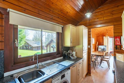 a kitchen with a sink and a window in a cabin at Lady Galloway 28 with Hot Tub in Newton Stewart