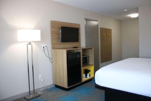 a hotel room with a bed and a tv and a bed gmaxwell gmaxwell gmaxwell gmaxwell at Days Inn by Wyndham Waco University Area in Waco