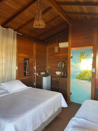 a bedroom with a bed and a bathroom with a sink at Pousada BANGALÔS SOL DE LAGOINHA in Lagoinha