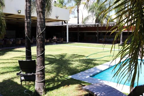 um pátio com um campo de ténis e palmeiras em Wyndham Garden Aguascalientes Hotel & Casino em Aguascalientes