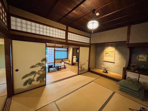 a room with a japanese room with a door and a room with at Sangai Ryokan in Gotsu