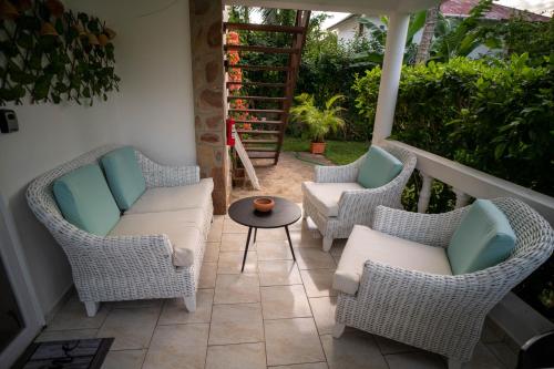 a patio with wicker chairs and a table at Charming 1 bdr apt w/ pool 5min Popi beach in Las Terrenas