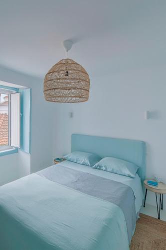 a blue bedroom with a bed and a table at Casa Azul do Olival in Alcácer do Sal