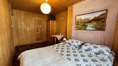 - une chambre avec un lit et une photo sur le mur dans l'établissement Na Dolinie, à Bukowina Tatrzańska