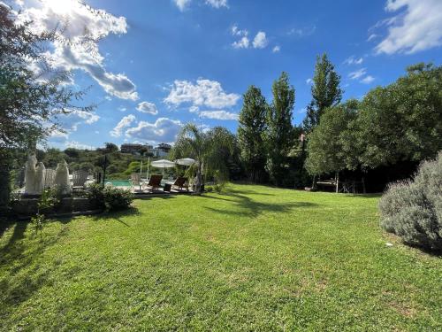 a large yard with grass and trees on a sunny day at Agrippina in Villa Carlos Paz