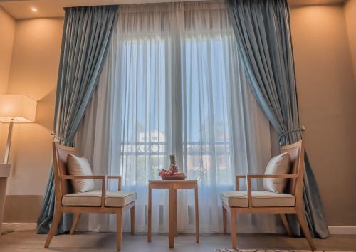 a room with two chairs and a window at Haile Grand Addis Ababa in Addis Ababa