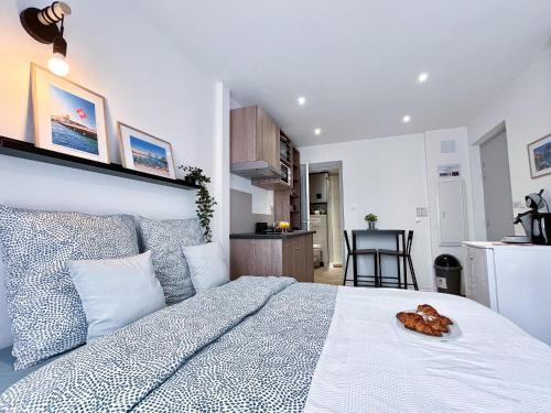 1 dormitorio con 1 cama blanca grande y cocina en LA MASCOTTE en Saint-Louis