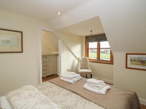 a bedroom with a bed with towels on it at Stable Cottage in Bishops Castle