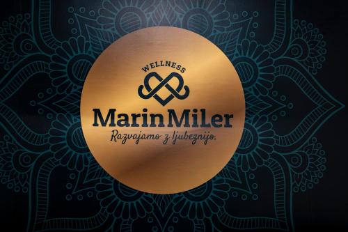 a gold medal with marlin miller logo on a black background at Vila Marin Miler in Prevalje